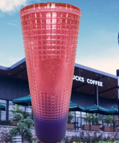 Starbucks Watermelon Ombre Tumbler displayed in front of a Starbucks coffee shop and drive thru sign