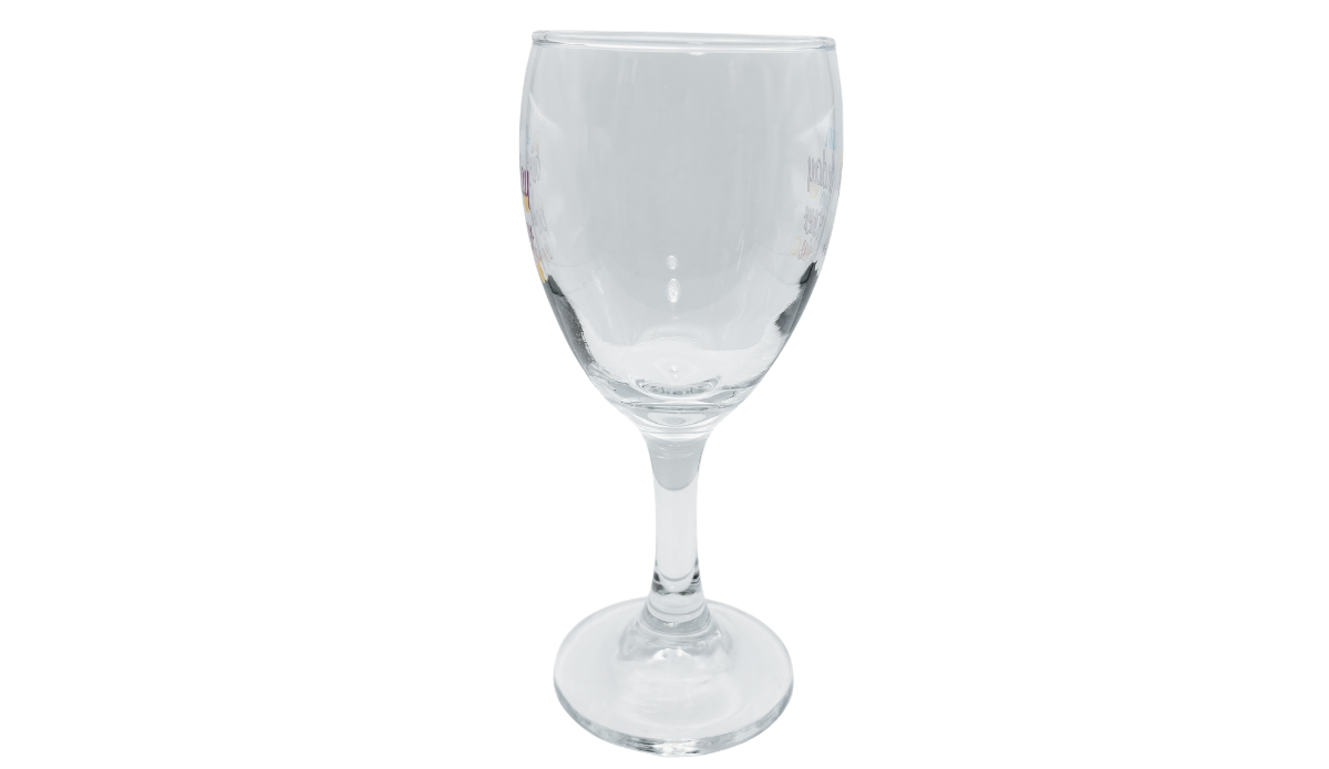 Right side view of Happy Birthday Partner In Wine Glass showing the clear rounded bowl, partial colorful lettering at both edges, and slender stem.