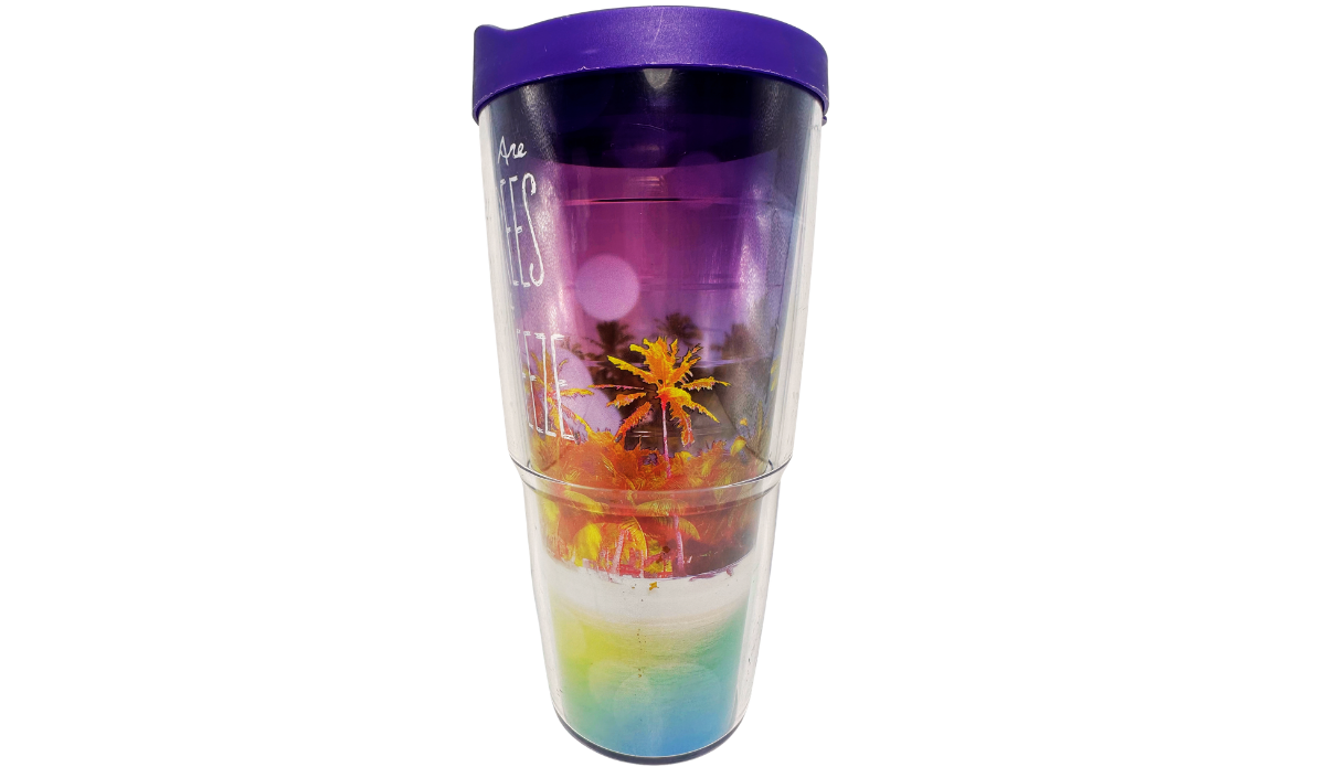 Right side view of Tervis Palm Trees Cool Breeze Tumbler With Lid showing partial white lettering, purple sunset sky, orange palm trees, and turquoise water.