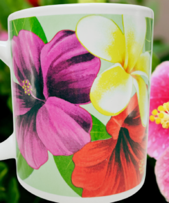 Kauai Tropical Hibiscus Plumeria Coffee Mug lifestyle scene featuring pink hibiscus artwork and white-yellow plumeria against a vibrant red hibiscus flower background.