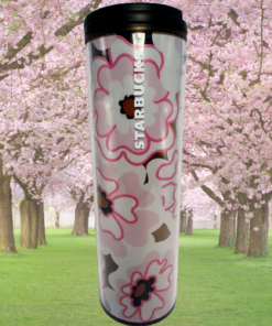 Starbucks Sakura Tumbler displayed in front of cherry blossom trees with pink blooms and green grass